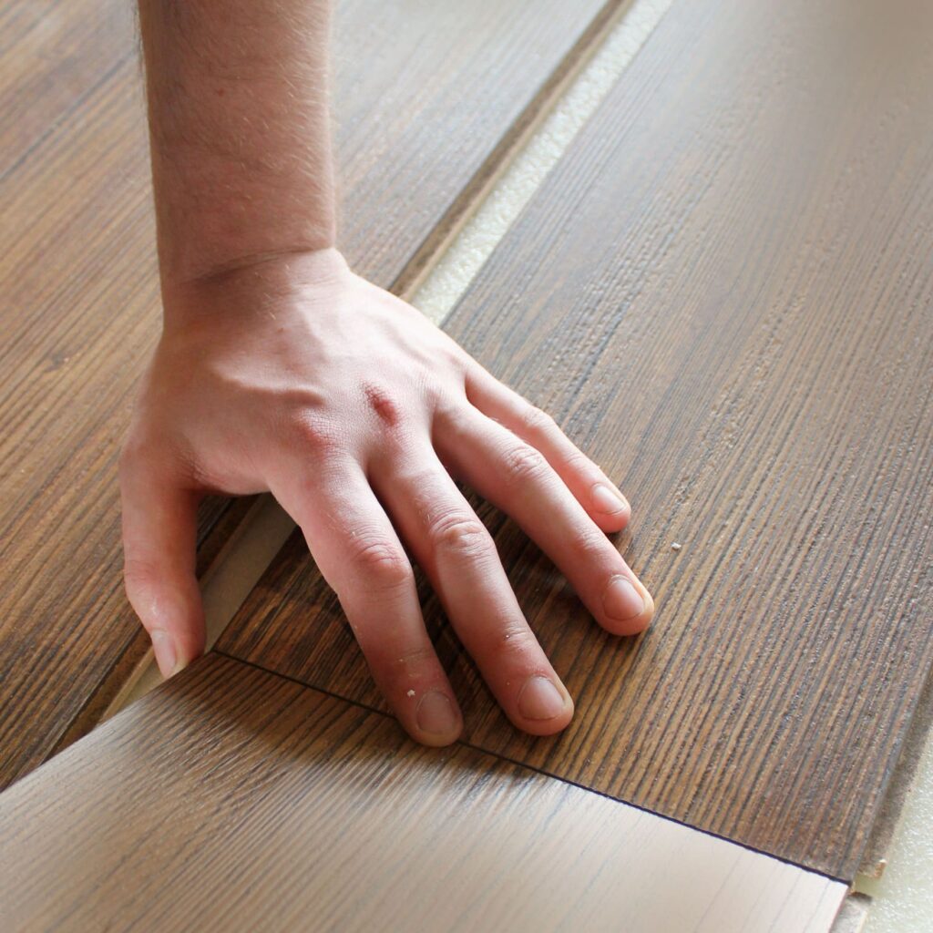 laminate-flooring-male-repairman-is-laying-panel-laminate-floor polaganje laminata